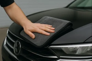 دستمال میکروفایبر در حال پاک‌سازی بدنه خودرو